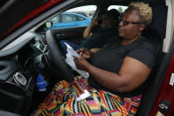 While sitting in a car with her husband, Gloria Allen looks at instructions for an asthma inhaler outside a pharmacy in Dallas on Tuesday, Oct. 26, 2021. The couple lives near a compressor station for natural gas in Dalworthington Gardens, Texas. Gloria Allen said that, after two years living there, she was diagnosed with asthma. "It's driving me crazy," she said of fumes in her neighborhood that often come from the direction of the station. "It's coming through the fence. I smell it in the house. I'm going to move. I can't take it." (AP Photo/Martha Irvine)