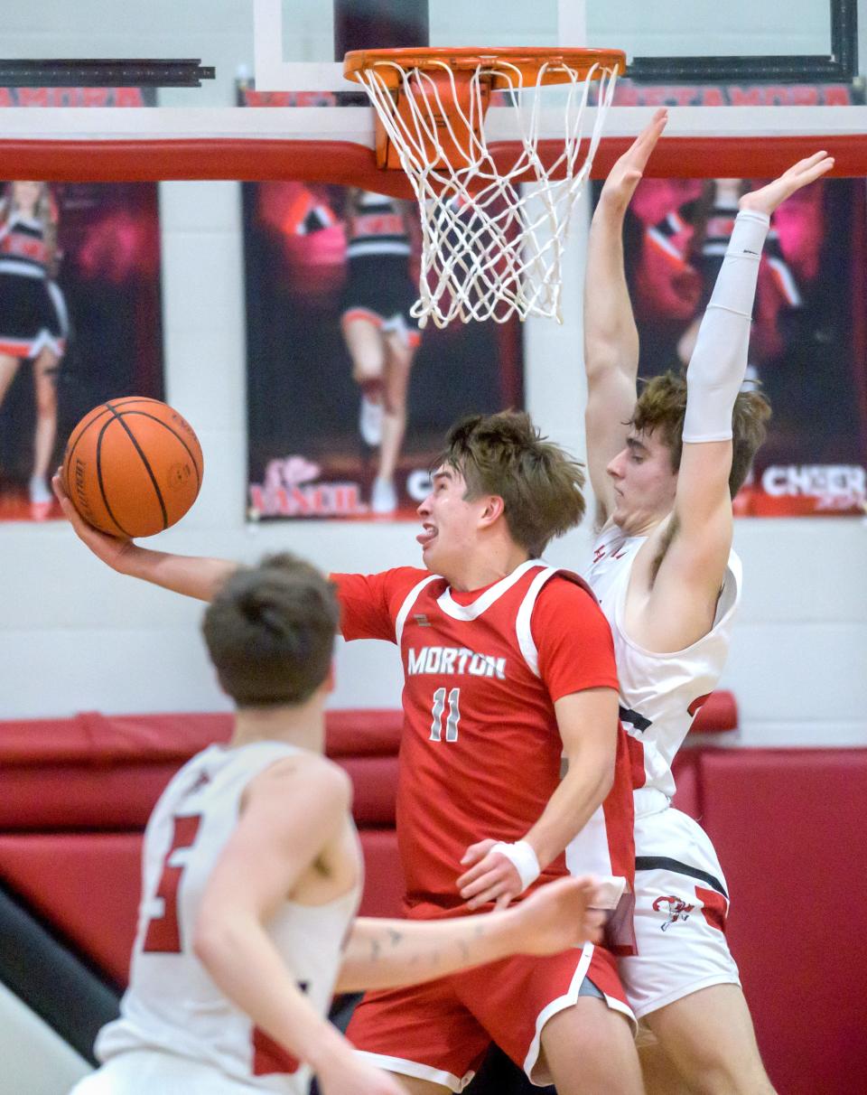 Morton's Gus Rugaard (11) moves to the basket against Metamora's Tyler Mason in the first half of their Mid-Illini Conference basketball game Tuesday, Jan. 23, 2024 in Metamora. The Redbirds defeated the Potters 67-48.