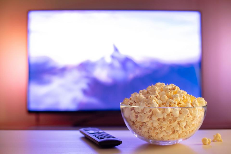 glass bowl of popcorn and remote control