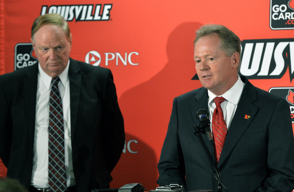 Bobby Petrino, right, address reporters as University of Louisville President D. James R. Ramsey looks on following the announcement of Petrino's hiring as football coach, Thursday, Jan. 9, 2014, at Papa John's Cardinal Stadium in Louisville, Ky. (AP Photo/Timothy D. Easley)