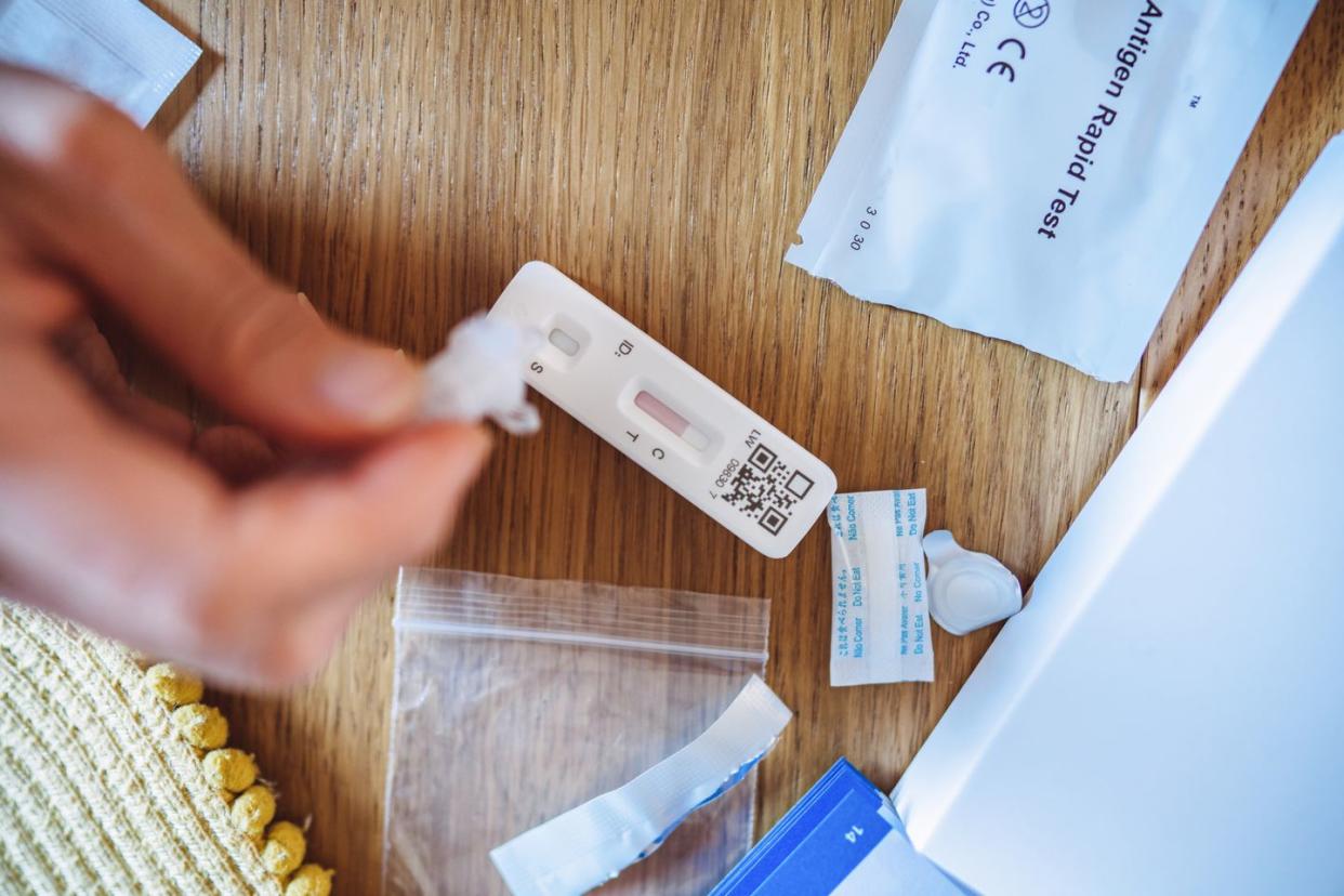 a woman using covid 19 rapid self test kit at home