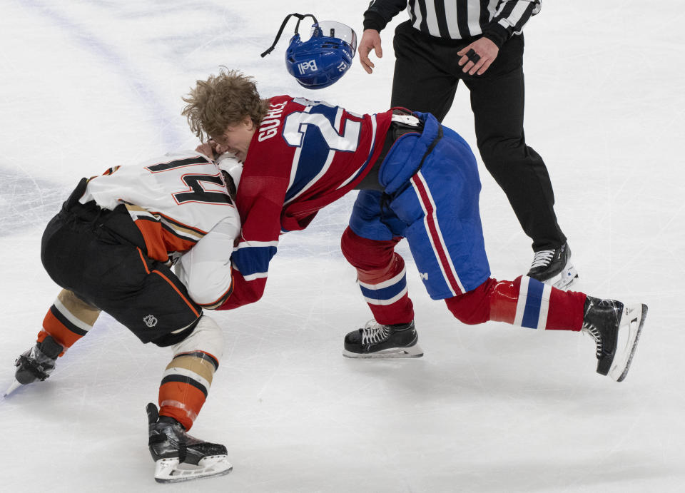 Montreal Canadiens' Kaiden Guhle (21) and Anaheim Ducks' Adam Henrique (14) fight during the third period of an NHL hockey game Tuesday, Feb. 13, 2024, in Montreal. (Christinne Muschi/The Canadian Press via AP)