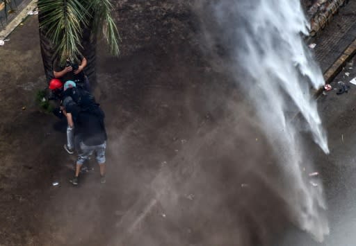 Demonstrators clash with riot police following a protest against the government of Chilean President Sebastian Pinera in Santiago, on November 8, 2019