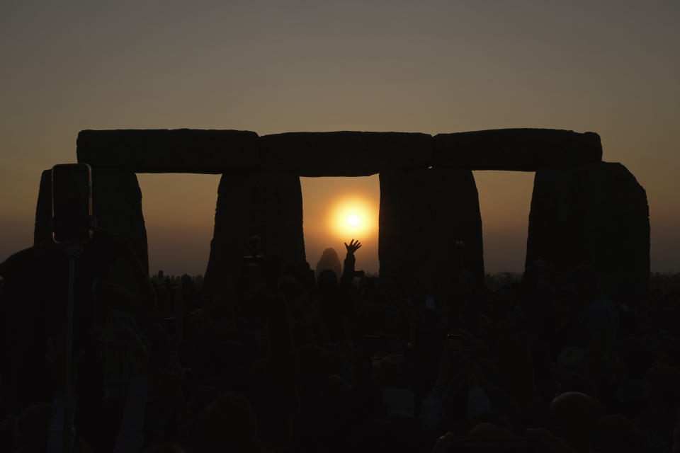 Revelers gather at the ancient stone circle Stonehenge to celebrate the Summer Solstice, the longest day of the year, near Salisbury, England, Wednesday, June 21, 2023. Druids, pagans, hippies, local residents, tourists and costumed witches and wizards have gathered around a prehistoric stone circle on a plain in southern England to express their devotion to the sun. (AP Photo/Kin Cheung)