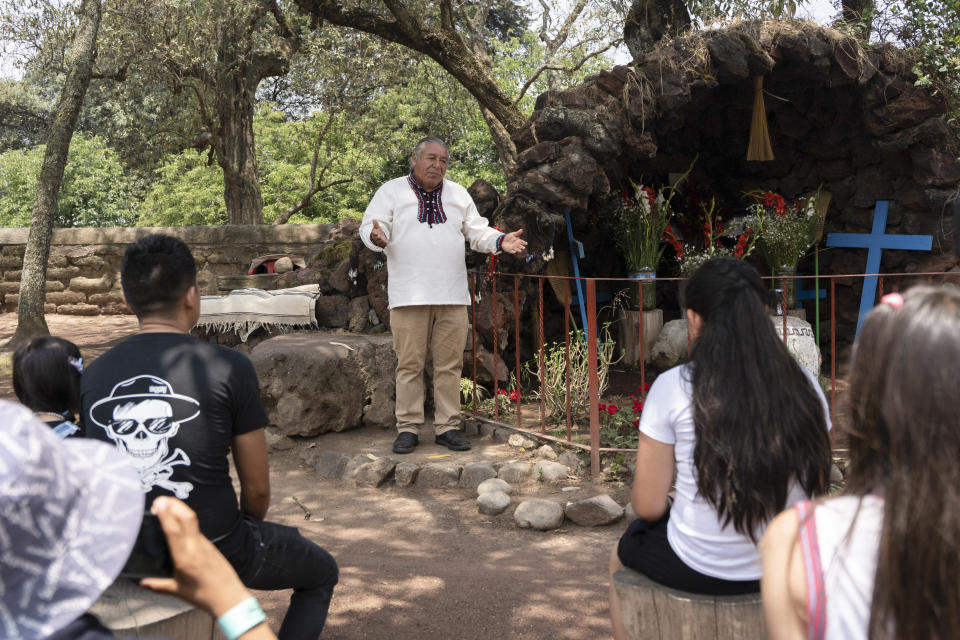 Moisés Vega cuenta la historia del volcán Popocatépetl a turistas, junto a una réplica del santuario que los pobladores han dedicado al volcán, en el Museo del Volcán en Amecameca, México, el domingo 11 de junio de 2023. Vega, un "granicero", también trabaja como un sanador tradicional. (AP Foto/Áurea Del Rosario)