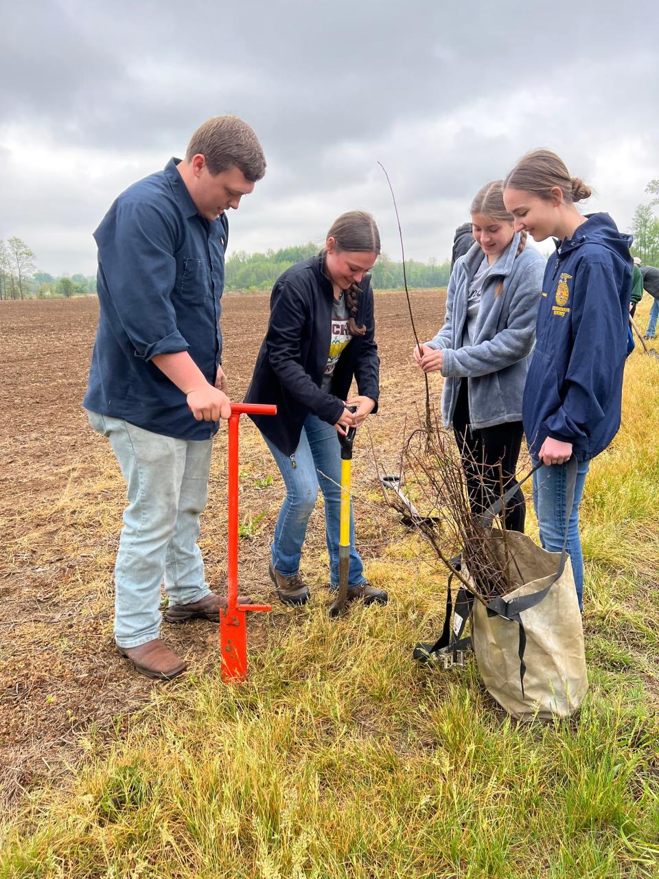 Ag student Lorelei Duncan (second from left) presses a spade into ground on Green River National Wildlife Refuge ground along Green River Road No. 2 last Friday while Austin McHatton, Ana Tichenor and Anna Bennett watch. Twenty-four Henderson County High ag students planted hardwood tree saplings that morning that will eventually provide habitat for wildlife on the refuge.