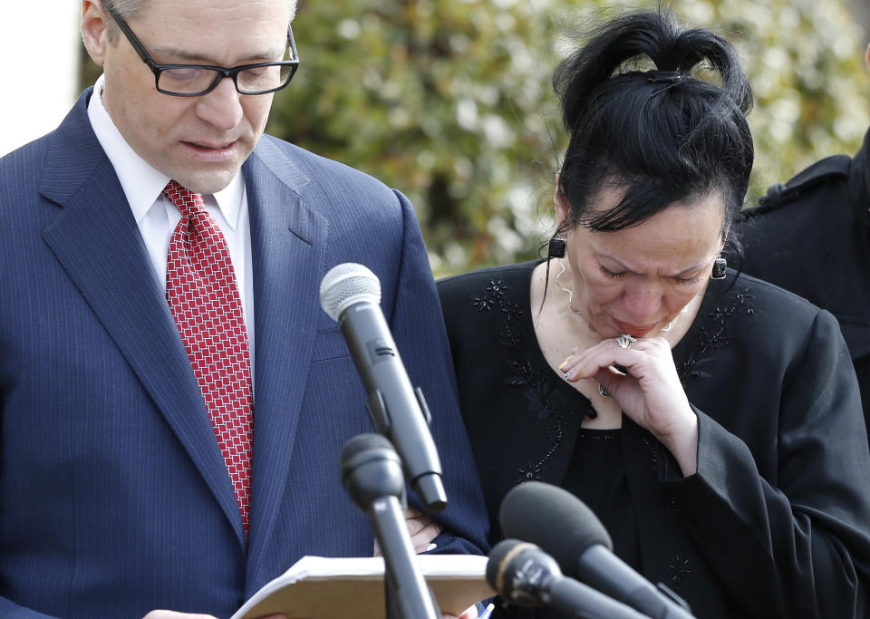 Attorney Michael Brooks-Jimenez, left, speaks at a news conference in Oklahoma City, Tuesday, Feb. 25, 2014. At right is Nair Rodriguez. At the news conference, the family of Luis Rodriguez, a man who died after a struggle with police outside an Oklahoma movie theater, released a cellphone video of the incident that shows the man on his stomach on the ground with five officers restraining him, including one officer holding his head down. (AP Photo/Sue Ogrocki)