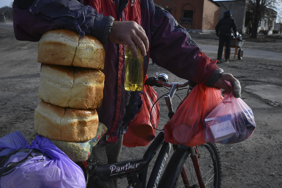 Local resident receives a food at a mobile humanitarian aid point in the village of Zarichne, Donetsk region, Ukraine, Friday, Dec. 2, 2022. (AP Photo/Andriy Andriyenko)