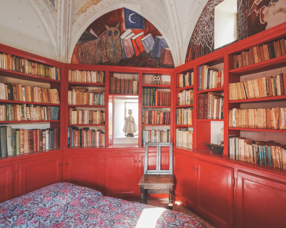 French guest bedroom with red bookcase, vaulted ceiling, owl mural, small window, chair