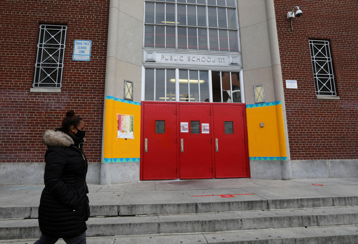 A woman walks past the entrance of a public school in New York, the United States, on Nov. 19, 2020. (Wang Ying/Xinhua via Getty)