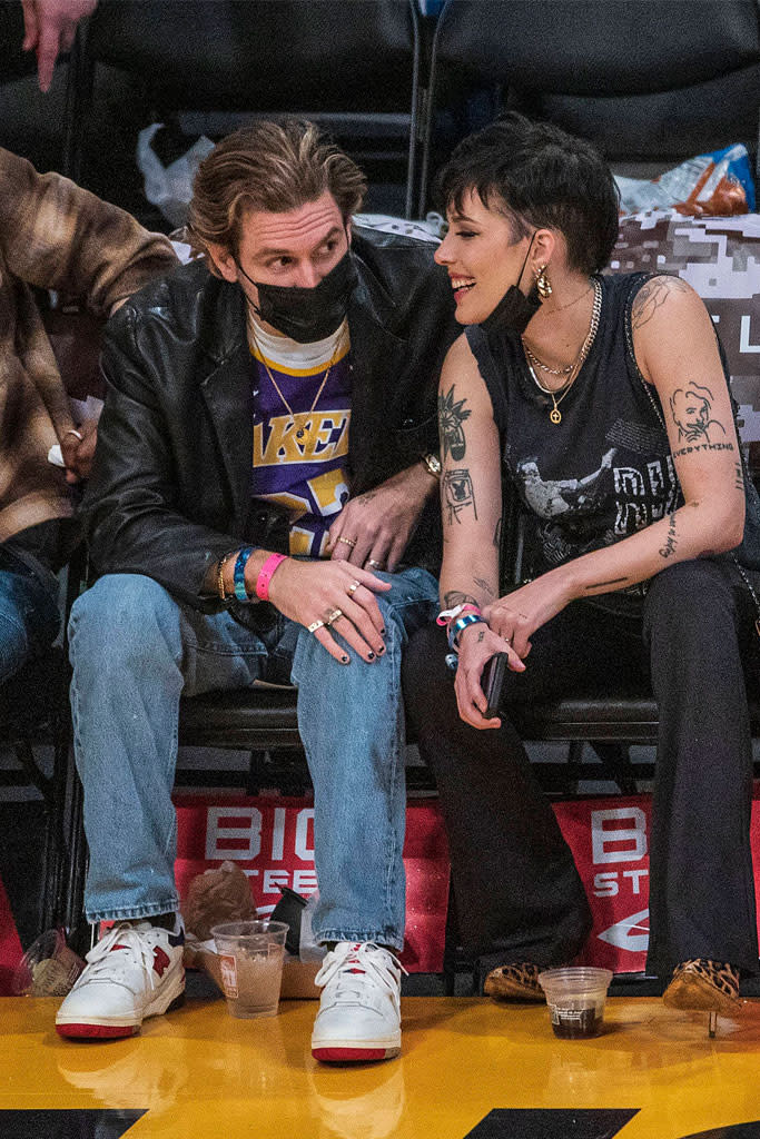 Halsey wearing a black tank top and jeans with a pair of leopard print boots at the Lakers vs. Pistons game with Alev Aydin. - Credit: MEGA