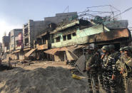 Indian security officers guard a street in a locality experiencing violence between two groups in Bhajanpura are of New Delhi, India, Tuesday, Feb. 25, 2020. At least seven people, including a police officer, were killed and dozens injured in the clashes, police said Tuesday. (AP Photo/Sheikh Saaliq)