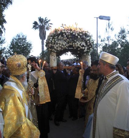 A Greek Orthodox bishop and an Islamic cleric attend a Good Friday liturgy at the Church of St. George Exorinos in Famagusta, northern Cyprus, April 18, 2014. REUTERS/Andreas Manolis