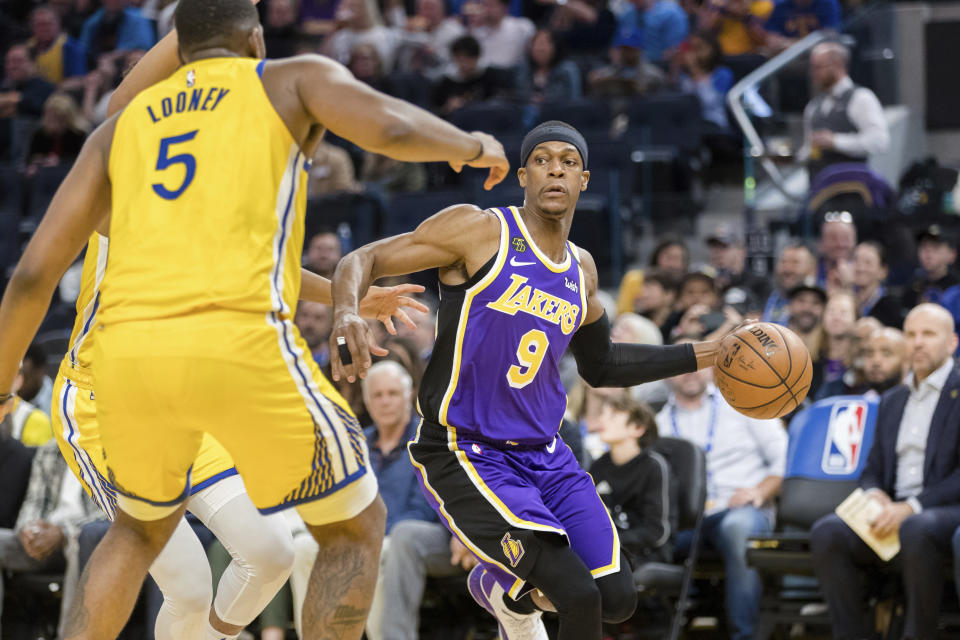 Los Angeles Lakers guard Rajon Rondo (9) dribbles as Golden State Warriors forward Kevon Looney (5) defends in the first half of an NBA basketball game in San Francisco Saturday, Feb. 8, 2020. (AP Photo/John Hefti)