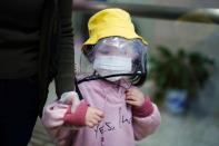 Child wearing a face mask and a face shield is seen at a railway station in Xianning