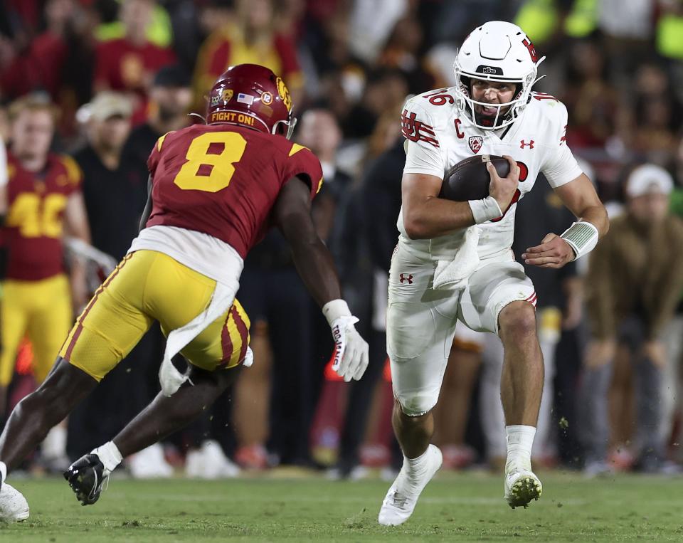 Utah Utes quarterback Bryson Barnes (16) runs past USC Trojans safety Zion Branch (8) as the Utes and the USC Trojans face each other on Saturday, Oct. 21, 2023.