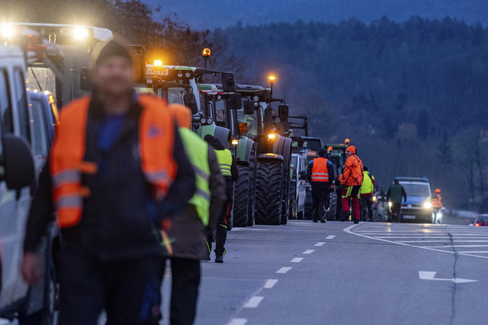 Tractors of protesting farmers block the entrance to the A3 highway in Kirchroth, Germany, Monday, Jan. 8, 2024. Farmers blocked highway access roads in parts of Germany Monday and gathered for demonstrations, launching a week of protests against a government plan to scrap tax breaks on diesel used in agriculture.(Armin Weigel/dpa via AP)