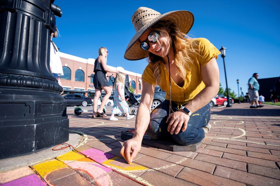 Artist Elisha Gallegos creates chalk art pieces during a 2021 VIBES Event.