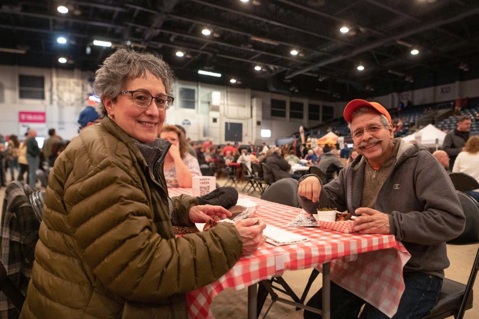 Battle Creek residents Chris and Pat Huot enjoy barbecue samplings during Que the Creek BBQ Festival at Kellogg Arena in Battle Creek on Saturday, Feb. 4, 2023.