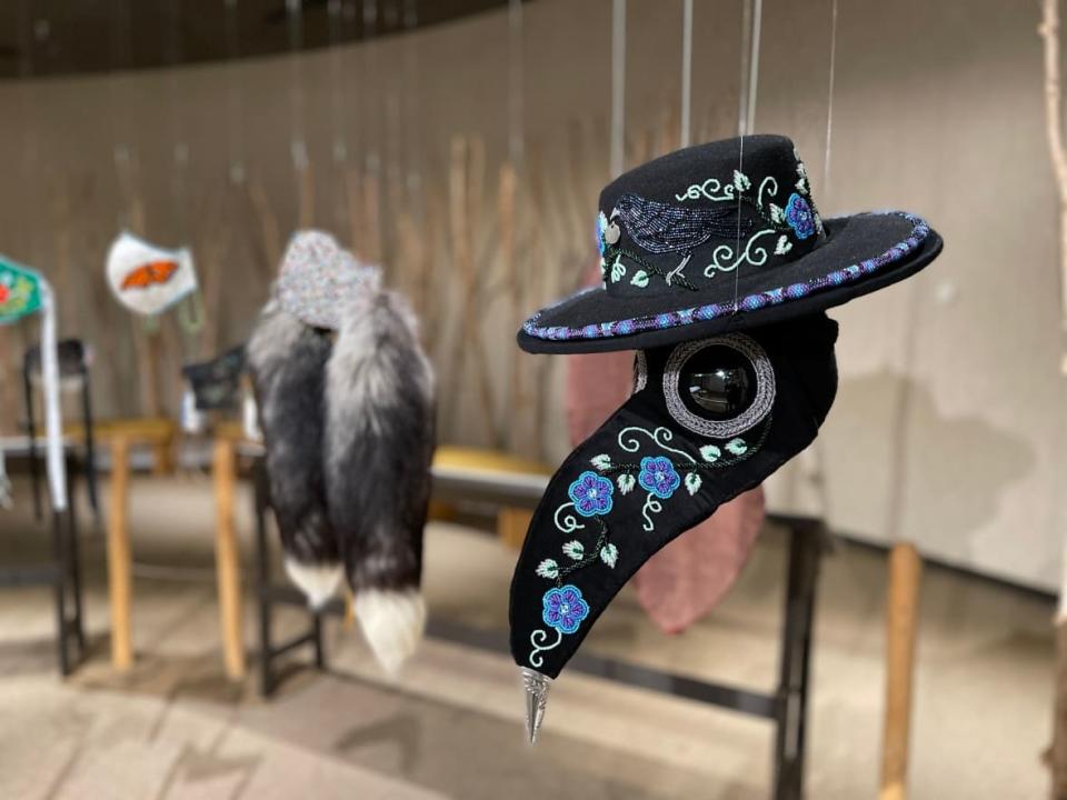 Corona Covid, a plague doctor-style mask with floral beadwork and a jingle cone for the  tip of the nose, by artist Towanna Miller.  (Kaicheng Xin/CBC - image credit)