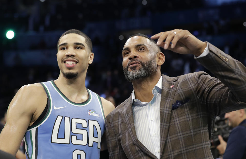 FILE - Former NBA player Grant Hill, right, speaks with Team USA player Jayson Tatum, of the Boston Celtics, both of whom played at Duke, after the NBA All-Star Rising Stars basketball game against the World Team, Friday, Feb. 15, 2019, in Charlotte, N.C. Let the recruiting begin. The braintrust for the U.S. — managing director Grant Hill, national team director Sean Ford and coach Steve Kerr — is already well into the process of trying to get players thinking about wearing the red, white and blue at the World Cup in 2023 as well as the Paris Olympics in 2024. (AP Photo/Chuck Burton, File)