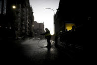 A worker disinfects the street outside Congress during a government-ordered lockdown to curb the spread of the new coronavirus in Buenos Aires, Argentina, Wednesday, April 8, 2020. (AP Photo/Natacha Pisarenko)