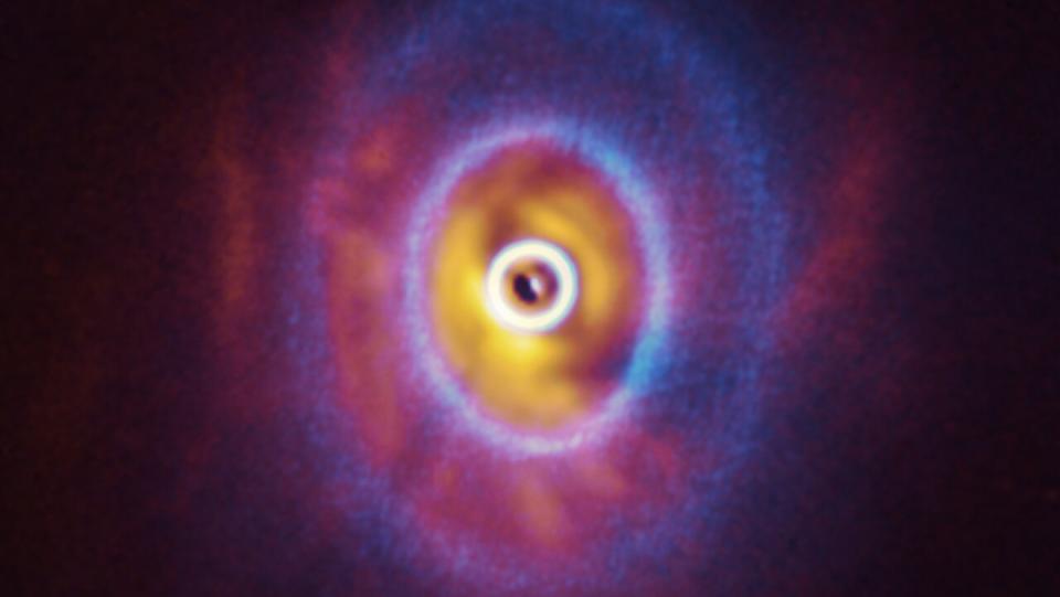 A visualization of a triple star system glowing in a cloud of matter.