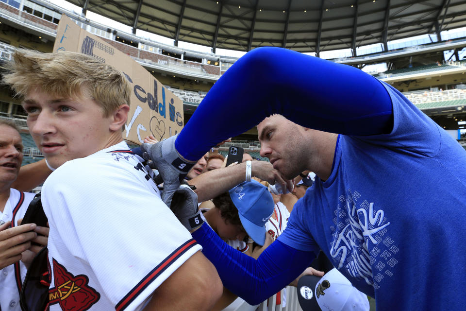 Los Angeles Dodgers first baseman Freddie Freeman (5) signs autographs for fans before the start of a baseball game against the Atlanta Braves Friday, June 24, 2022 in Atlanta. (AP Photo/Butch Dill)