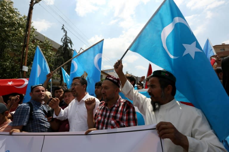 Uighur separatist supporters and Turkish supporters hold the flags of Turkey (far left) and East Turkestan, the term separatist Uighurs use for the Uighur homeland in Xinjiang, during a demonstration outside the Chinese embassy in Ankara on July 9, 2015