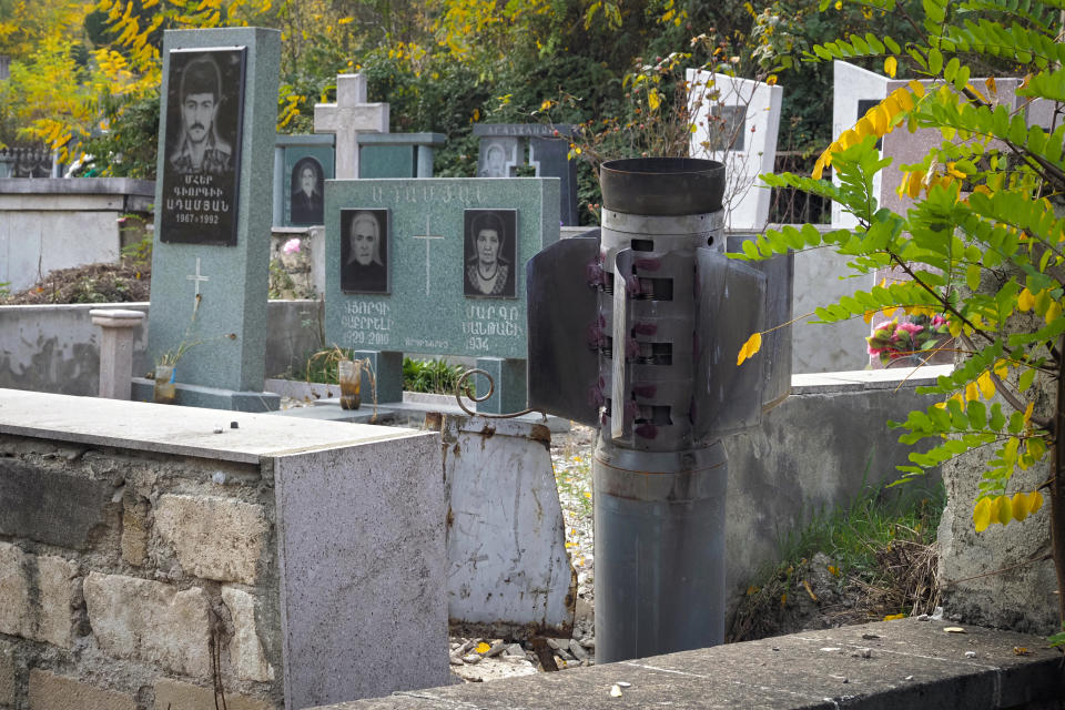 A tail of a multiple rocket 'Smerch' sticks out in a tomb at a cemetery, after shelling by Azerbaijan's artillery in Stepanakert, the separatist region of Nagorno-Karabakh, Tuesday, Nov. 3, 2020. Fighting over the separatist territory of Nagorno-Karabakh entered sixth week on Sunday, with Armenian and Azerbaijani forces blaming each other for new attacks. (AP Photo)