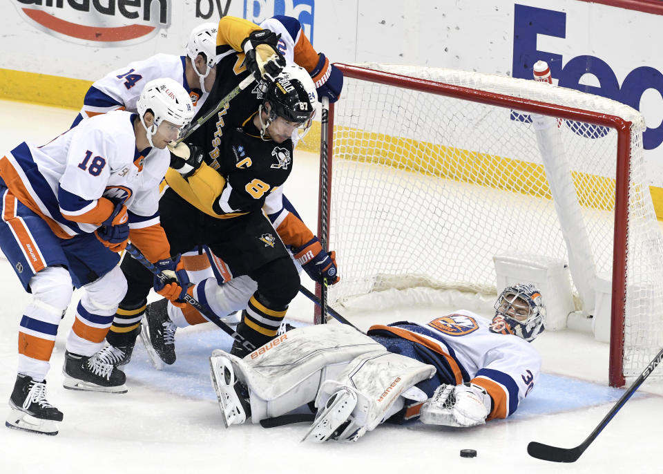 Pittsburgh Penguins captain Sidney Crosby (87) is stopped by New York Islanders goalie Ilya Sorokin (30) while being pressured by left wing Pierre Engvall (18) and defenseman Scott Mayfield (24) during the first period of an NHL hockey game, Thursday, March 9, 2023, in Pittsburgh. (AP Photo/Philip G. Pavely)