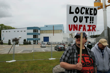 Michael Ansell, a carpenter with six years of experience, carries a sign with locked-out members of the Local 651 International Brotherhood of Boilermakers outside Westinghouse Electric's manufacturing facility in Newington, New Hampshire, U.S., May 22, 2017. REUTERS/Brian Snyder