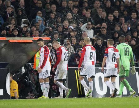 Supporters throw beer as players of Feyenoord leave the pitch after referee Clement Turpin of France called for a pause due to supporter unrest during their Europa League round of 32 second leg soccer match against AS Roma at the Kuip stadium in Rotterdam, February 26, 2015. REUTERS/Michael Kooren