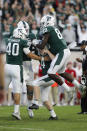 Michigan State's Jude Pedrozo (40), Trenton Gillison (88) and Tyler Hunt, rear, congratulate kicker Matt Coghlin (4) after his tie-breaking 21-yard field goal against Indiana with 5 seconds remaining during the fourth quarter of an NCAA college football game, Saturday, Sept. 28, 2019, in East Lansing, Mich. (AP Photo/Al Goldis)