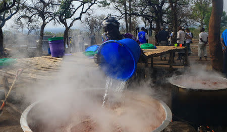 Social worker prepares warm meal for South Sudanese refugees displaced by fighting at Imvepi settlement in Arua district, northern Uganda, April 4, 2017. Picture taken April 4, 2017. REUTERS/James Akena