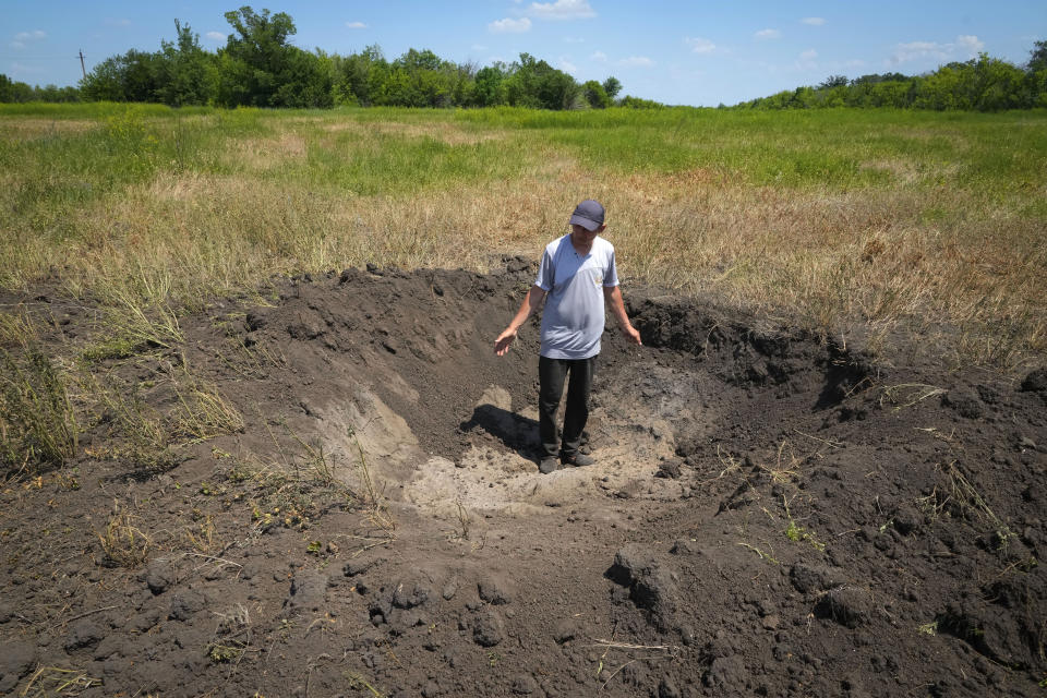 Farmer Serhiy, a local grain producer, shows a crater left by a Russian shell on his field in the village of Ptyche in eastern Donetsk region, Ukraine, Sunday, June 12, 2022. An estimated 22 million tons of grain are blocked in Ukraine, and pressure is growing as the new harvest begins. The country usually delivers about 30% of its grain to Europe, 30% to North Africa and 40% to Asia. But with the ongoing Russian naval blockade of Ukrainian Black Sea ports, millions of tons of last year’s harvest still can’t reach their destinations. (AP Photo/Efrem Lukatsky, File)