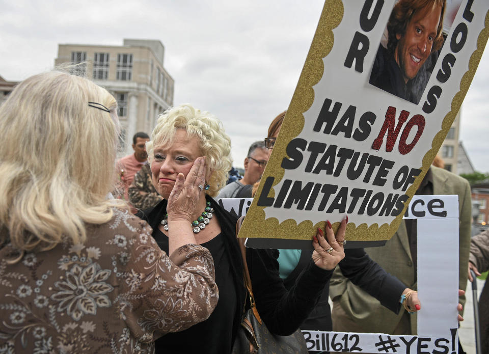 Cindy Leech, center, is greeted by Judy Deaven at the steps of the state Capitol at the conclusion of a march in support of legislation that would change the statute of limitations for child sex crimes, in Harrisburg, Pa., Monday, Sept. 24, 2018. A proposal to give victims of child sexual abuse a two-year window to sue over allegations that would otherwise be too old to pursue was overwhelmingly approved by the state House on Monday, as supporters cheered from the gallery. (Steve Mellon/Pittsburgh Post-Gazette via AP)