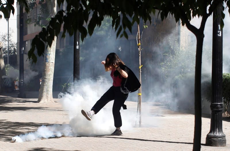 A demonstrator kicks a tear gas canister during a protest against the increase in the subway ticket prices in Santiago