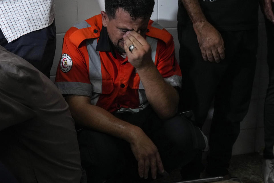 Palestinians mourn their colleague civil defense member killed in the Israeli bombardment of Nuseirat refugee camp, at the morgue of al-Aqsa Martyrs Hospital in Deir al Balah, central Gaza Strip, late Thursday, June 27, 2024. (AP Photo/Abdel Kareem Hana)