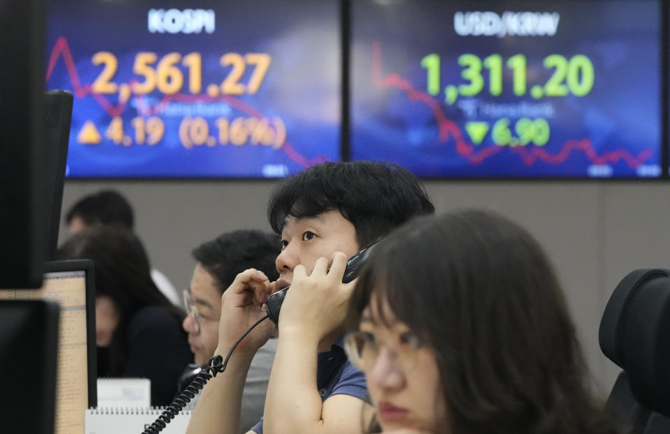 A currency trader watches monitors near the screens showing the Korea Composite Stock Price Index (KOSPI), top left, and the foreign exchange rate between U.S. dollar and South Korean won at the foreign exchange dealing room of the KEB Hana Bank headquarters in Seoul, South Korea, Tuesday, May 23, 2023. Asian stock markets were mixed Tuesday after more talks in Washington on government debt ended with no deal to avoid a potentially jarring default.(AP Photo/Ahn Young-joon)