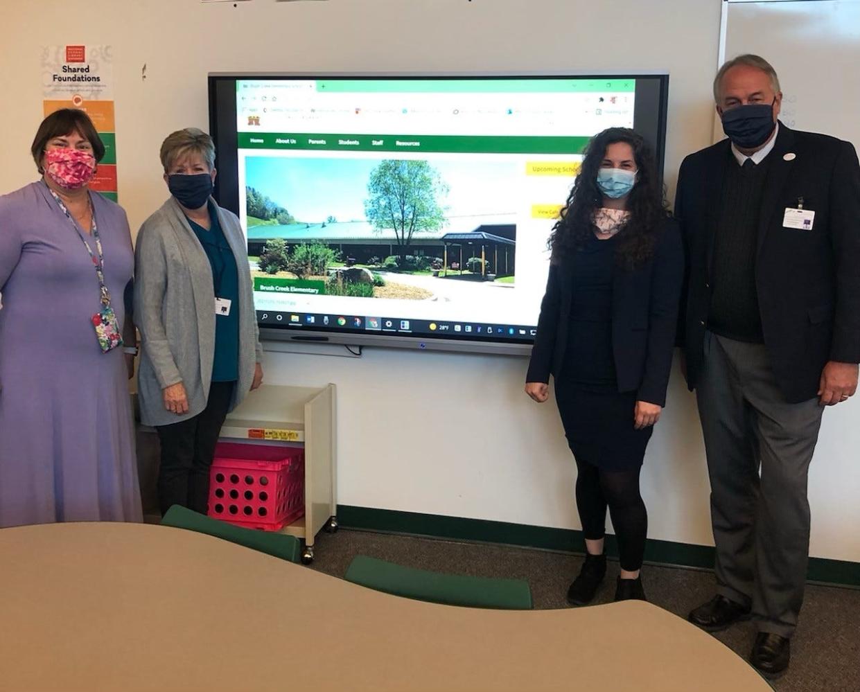 From left, music educator Roslyn Carney, school board chair Karen Blevins, Land of Sky regional planner Sara Nichols and Madison County Schools Superintendent Will Hoffman pose for a photo.