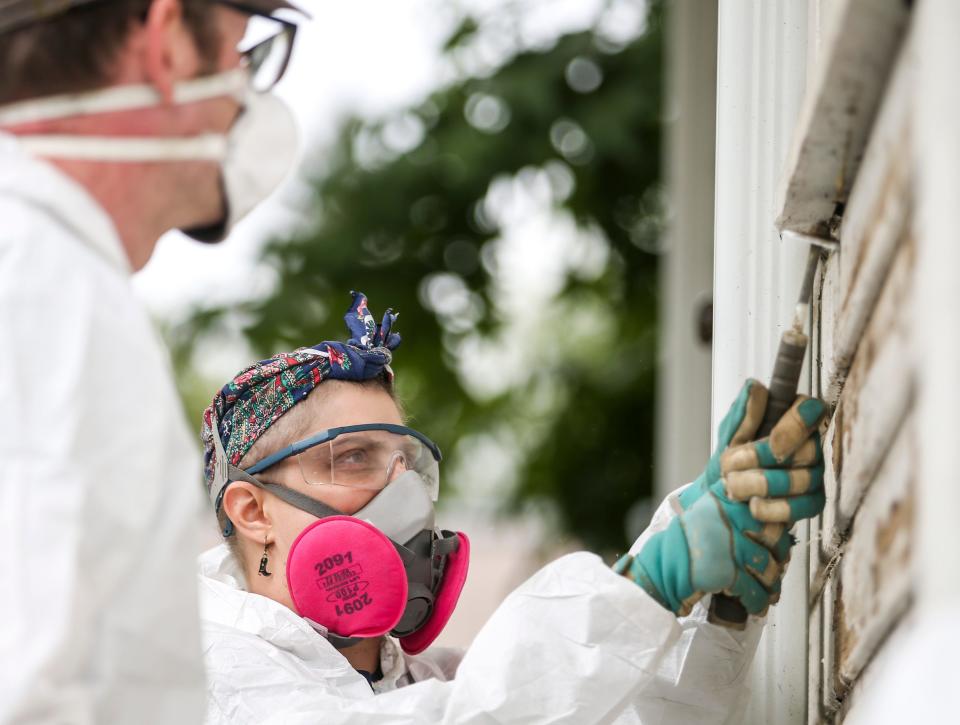 Lu Blanchard, a student from the Historic Preservation and Restoration program at Clatsop Community College, works with others to repair siding on the historical Criterion Schoolhouse at the Oregon State Fairgrounds.