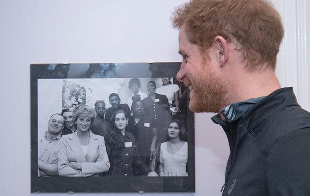 Harry pauses to look at pictures Princess Diana