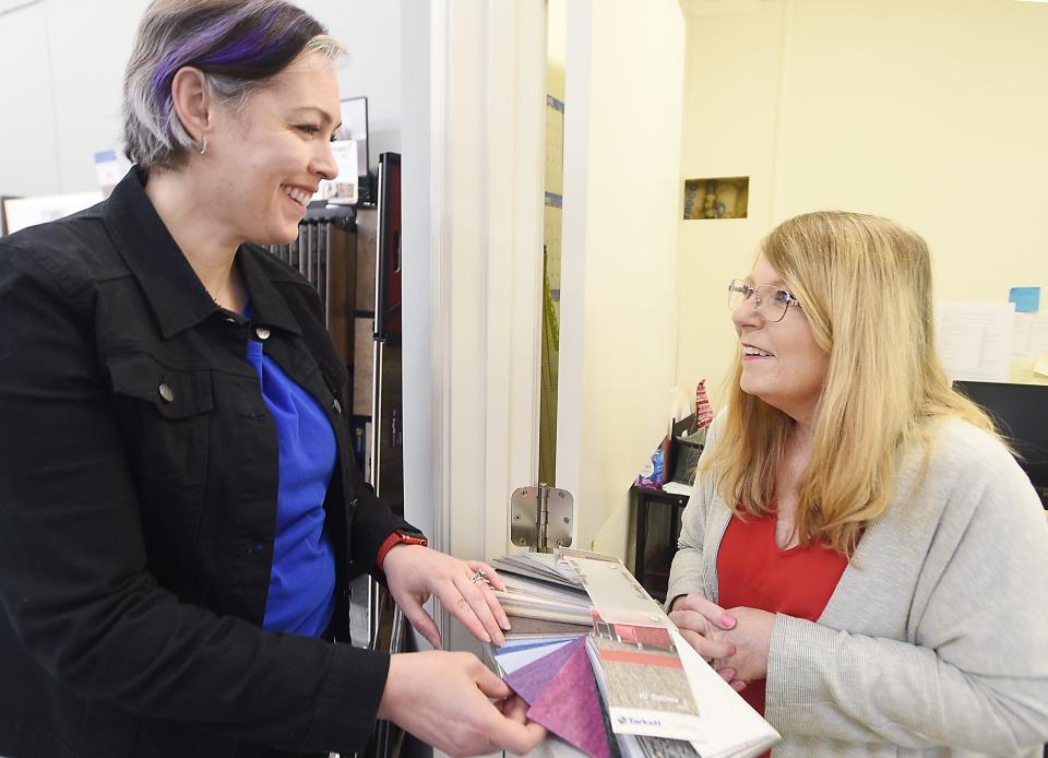 Mindy Nearhoof, left, owner of Annie's Flooring and Commercial Services, looks at new color samples of flooring with office manager Lori Irwin at the business in Meadville.