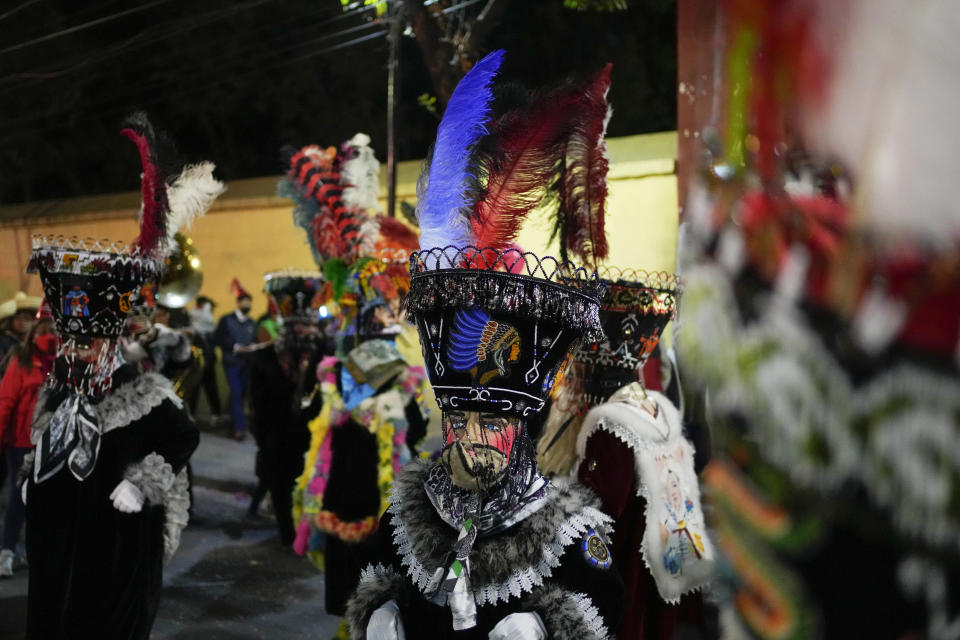 Mexican "chinelo" dancers participate in the procession of "Ninopan" during a Christmas "posada," which means lodging or shelter, in the Xochimilco borough of Mexico City, Wednesday, Dec. 21, 2022. For the past 400 years, residents have held posadas between Dec. 16 and 24, when they take statues of baby Jesus in procession to church for Mass to commemorate Mary and Joseph's cold and difficult journey from Nazareth to Bethlehem in search of shelter. (AP Photo/Eduardo Verdugo)