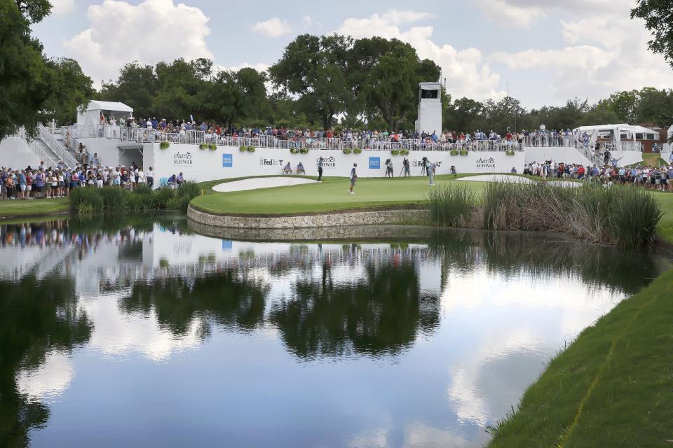 Jason Kokrak, right center, putts on the ninth green as Jordan Spieth, left, stands by a bunker and watches during the third round of the Charles Schwab Challenge golf tournament at Colonial Country Club in Fort Worth, Texas, Saturday May 29, 2021. (AP Photo/Ron Jenkins)