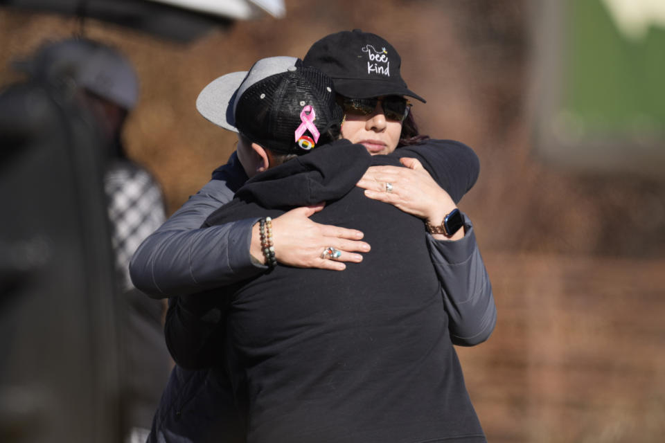 People hug along a makeshift memorial to victims of a weekend mass shooting at a nearby gay nightclub on Tuesday, Nov. 22, 2022, in Colorado Springs, Colo. Anderson Lee Aldrich opened fire at Club Q, in which five people were killed and others suffered gunshot wounds before patrons tackled and beat the suspect into submission. (AP Photo/David Zalubowski)