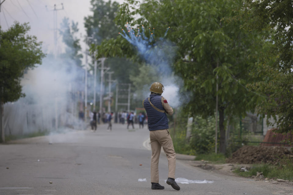 An Indian police man fires tear gas shell at Kashmir protesters near the site of a gunbattle in Pulwama, south of Srinagar, Indian controlled Kashmir, Thursday, May 16, 2019. Three rebels, an army soldier and a civilian were killed early Thursday during a gunbattle in disputed Kashmir that triggered anti-India protests and clashes, officials and residents said. (AP Photo/ Dar Yasin)