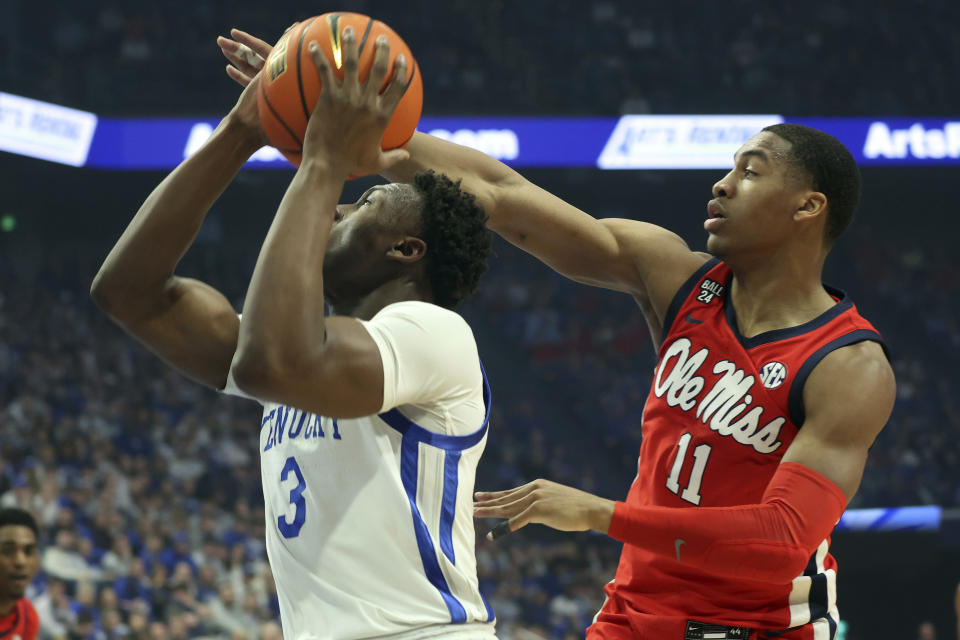 Kentucky's Adou Thiero (3) is pressured from behind by Mississippi's Matthew Murrell (11) during the first half of an NCAA college basketball game Tuesday, Feb. 13, 2024, in Lexington, Ky. (AP Photo/James Crisp)