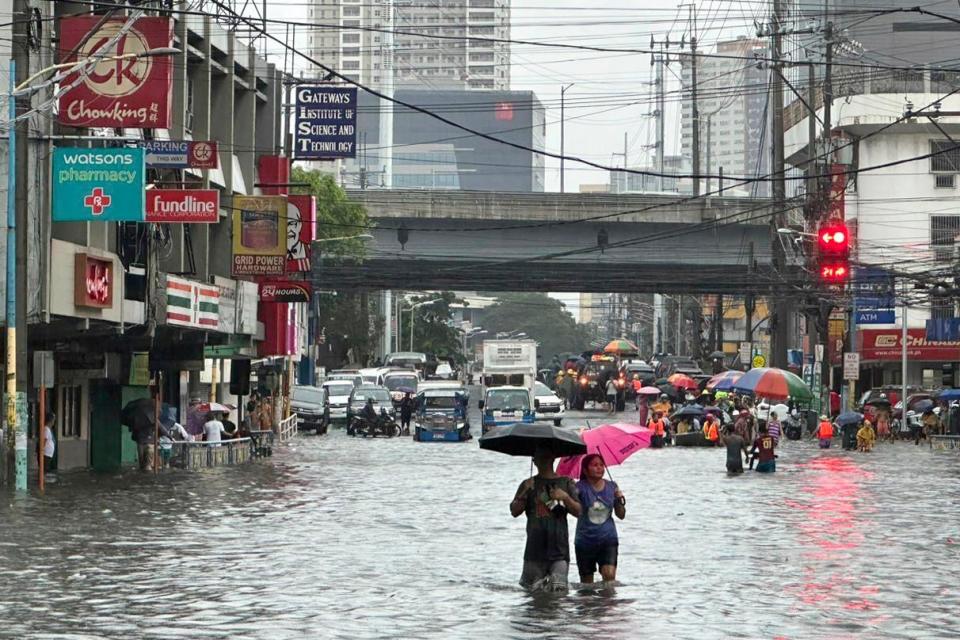 Streets flood from monsoon rains worsened by offshore typhoon Gaemi (AP)